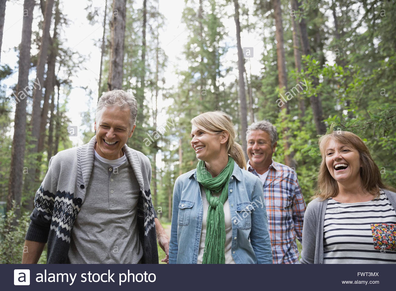 Middle-aged friends walking through the forest Stock Photo
