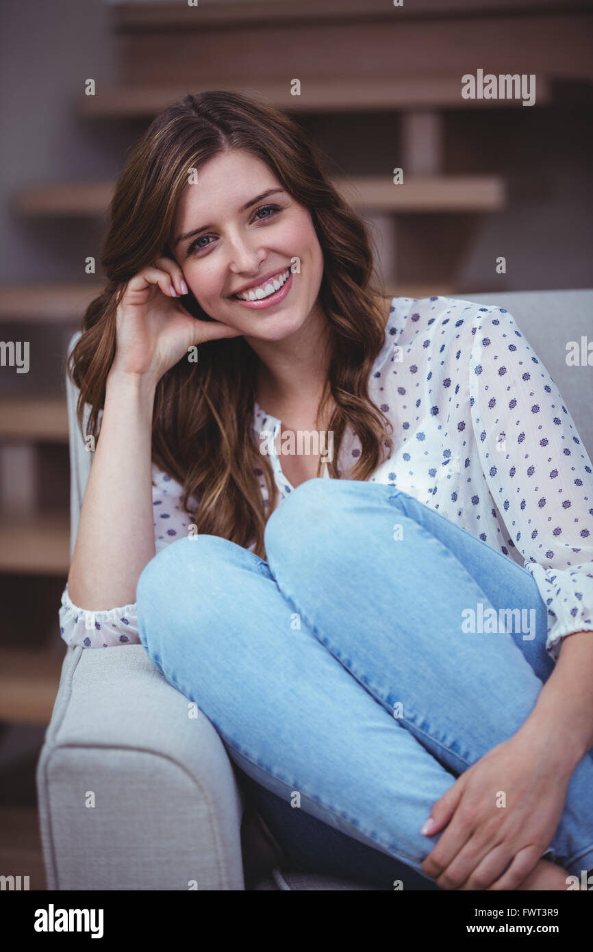 Portrait of beautiful woman sitting on sofa Stock Photo - Alamy