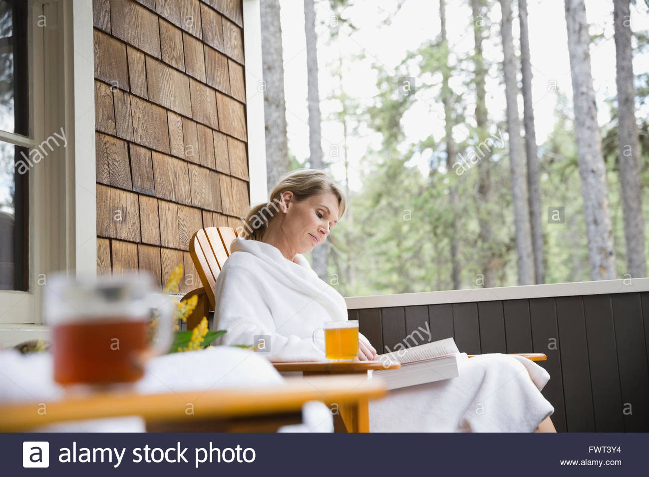 Woman relaxing on porch with a book Stock Photo - Alamy
