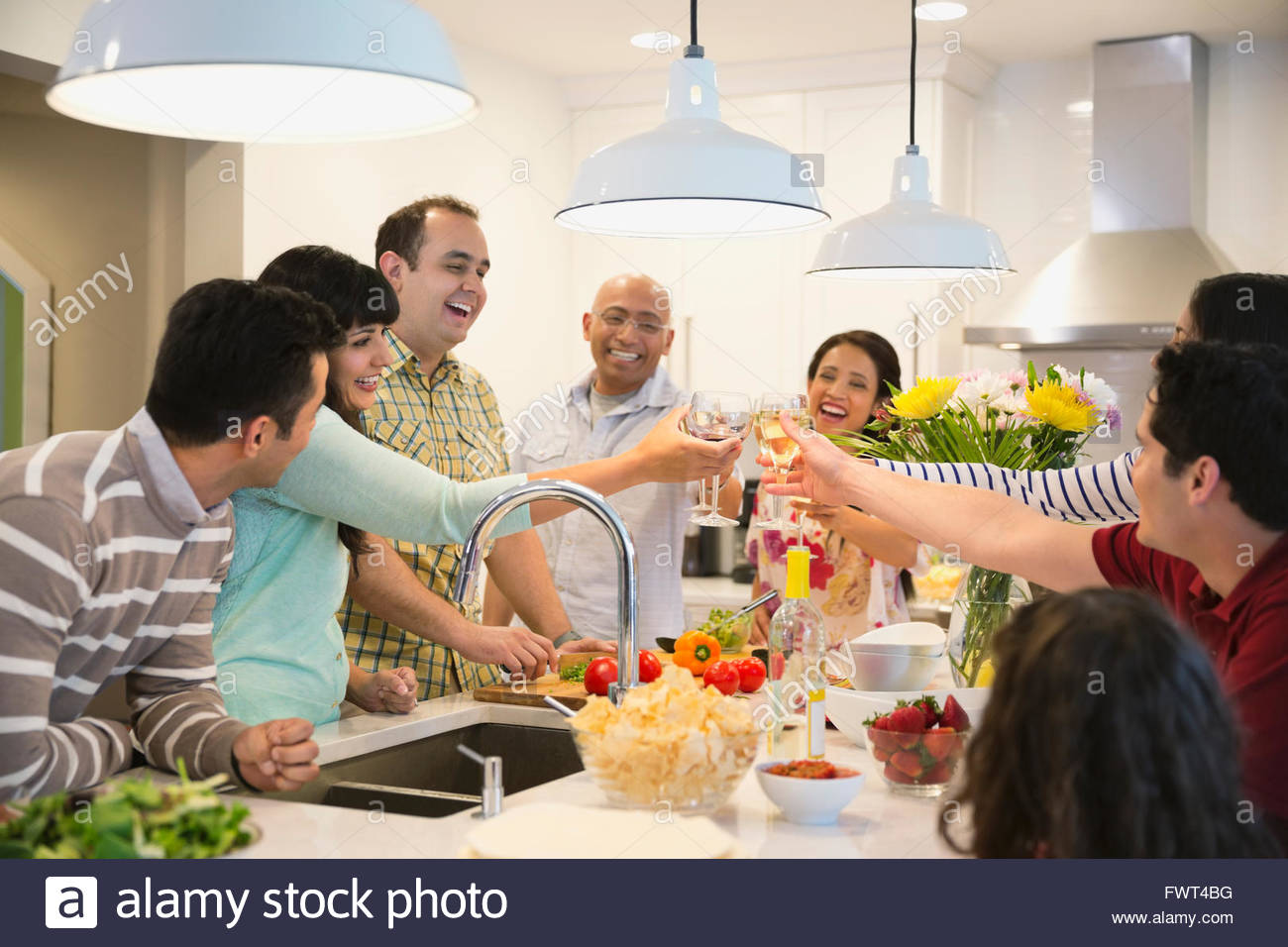 Friends Toasting in Kitchen Stock Photo