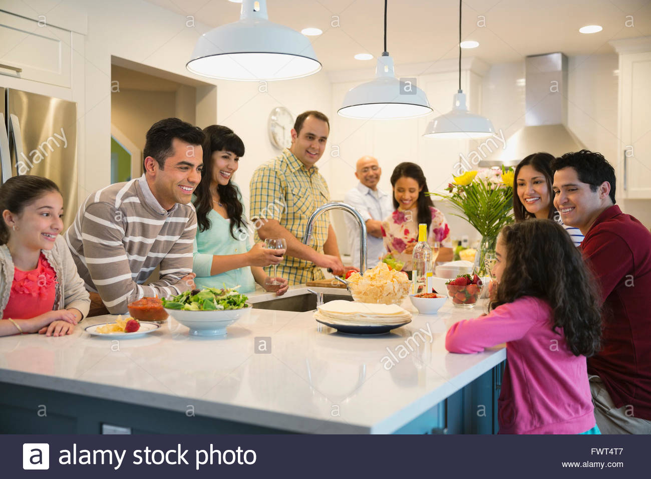 Family gathered around kitchen island Stock Photo