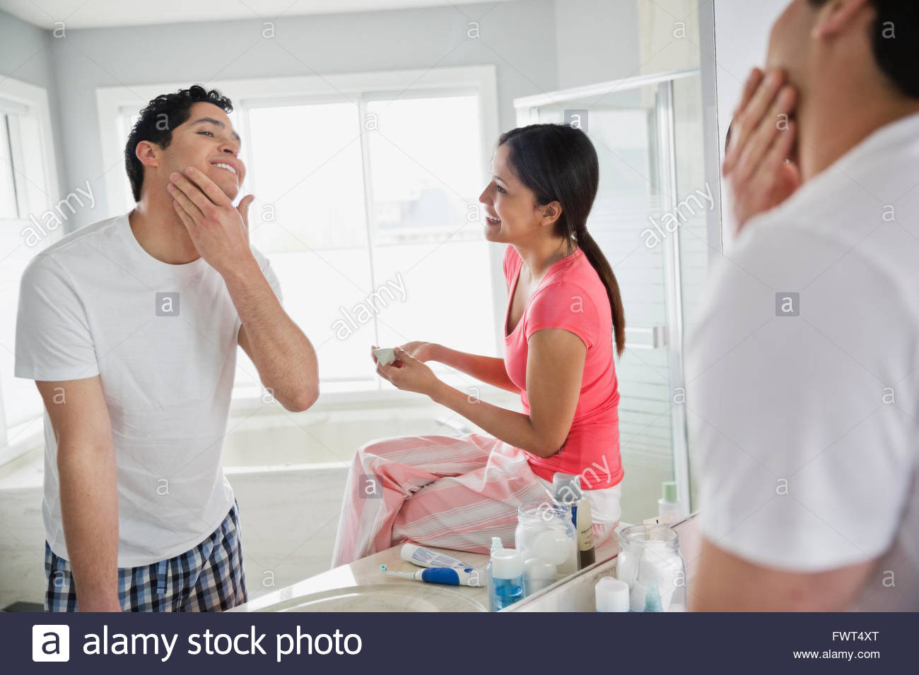 Man applying aftershave in bathroom Stock Photo