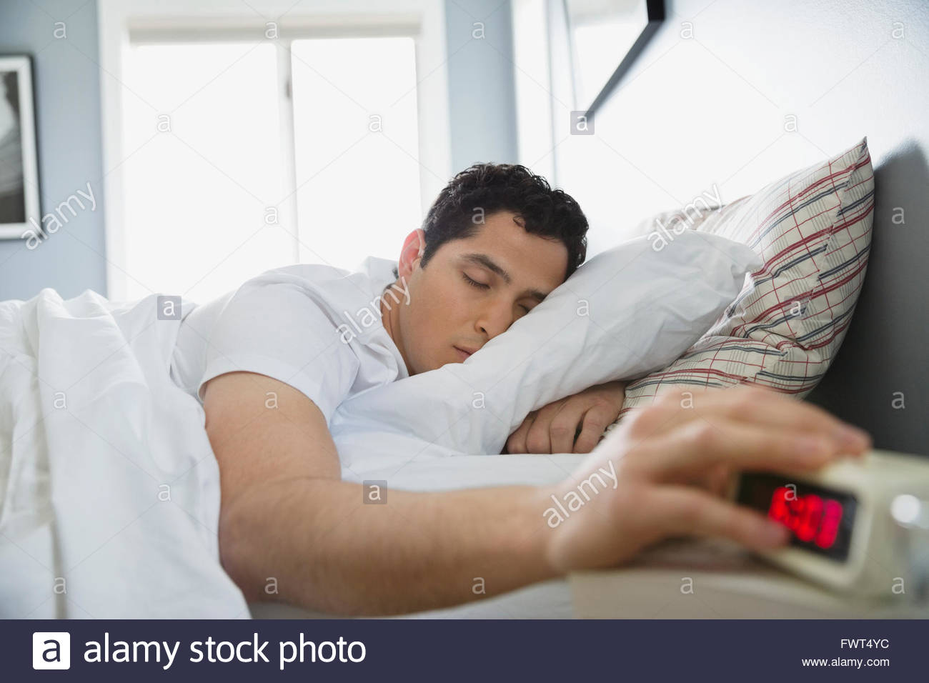 Man hitting snooze on alarm hires stock photography and images Alamy