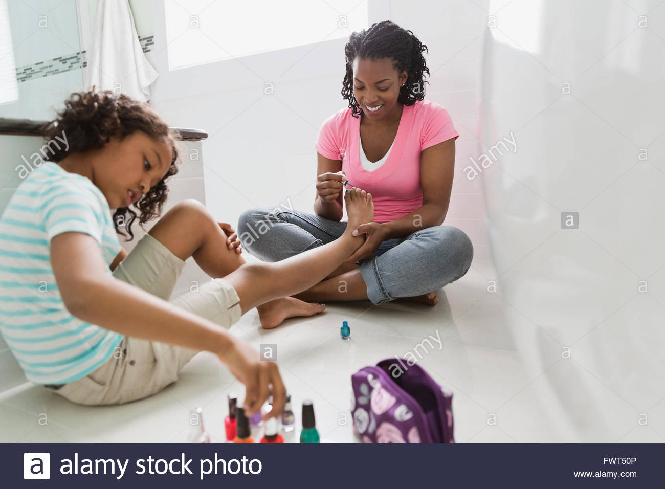 Mother painting daughters toenails hires stock photography and images