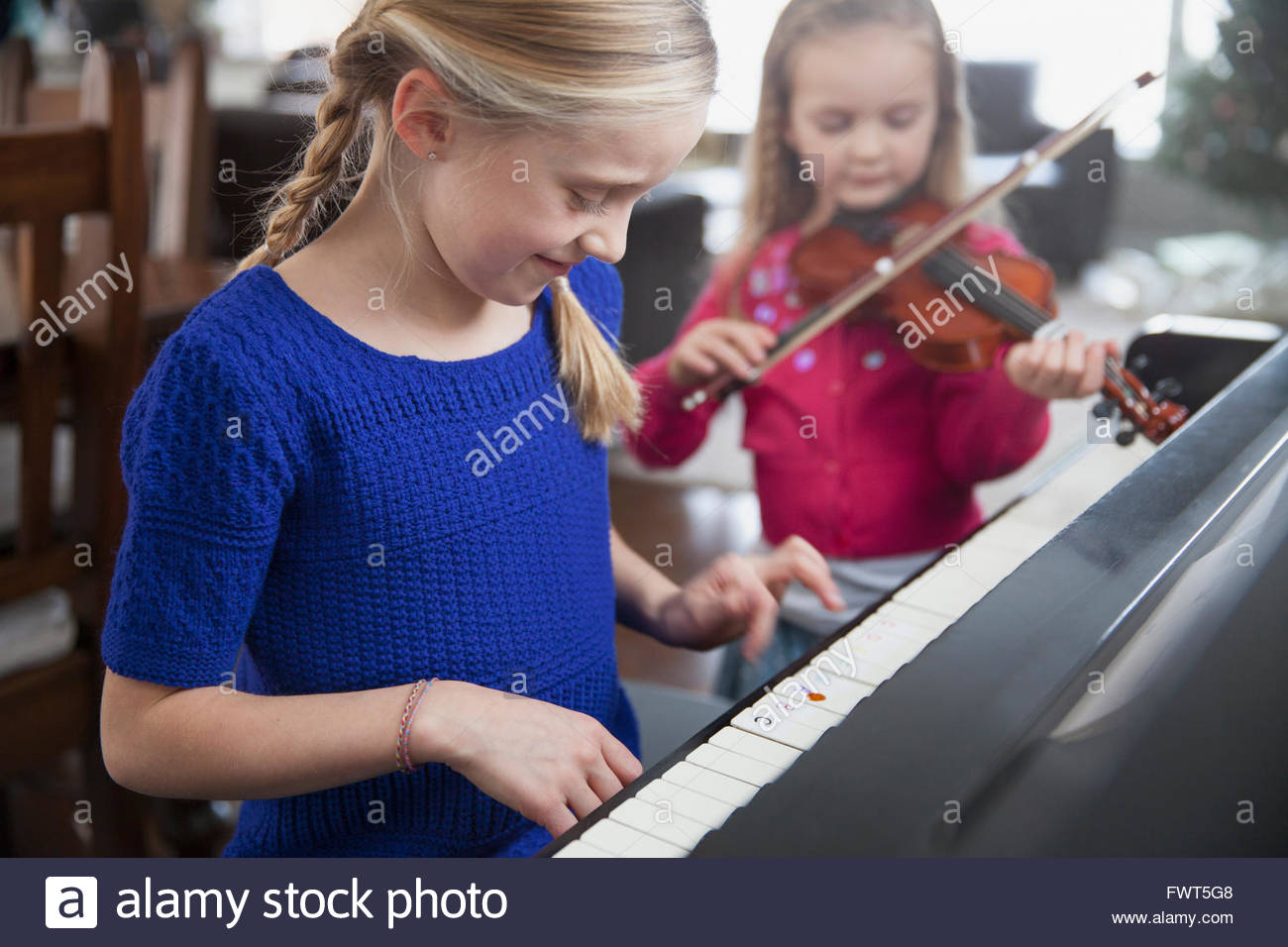 Young sisters practising music together Stock Photo