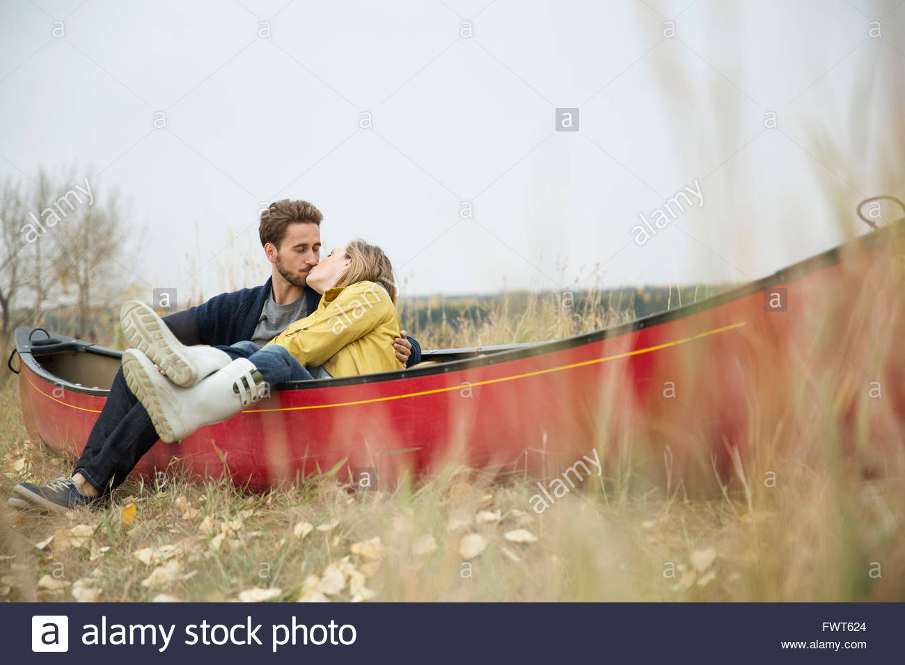 Romantic young couple kissing on grounded canoe Stock Photo Alamy