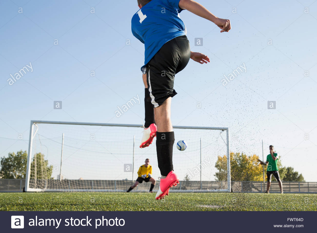 Coach watching soccer player kick the soccer ball Stock Photo Alamy