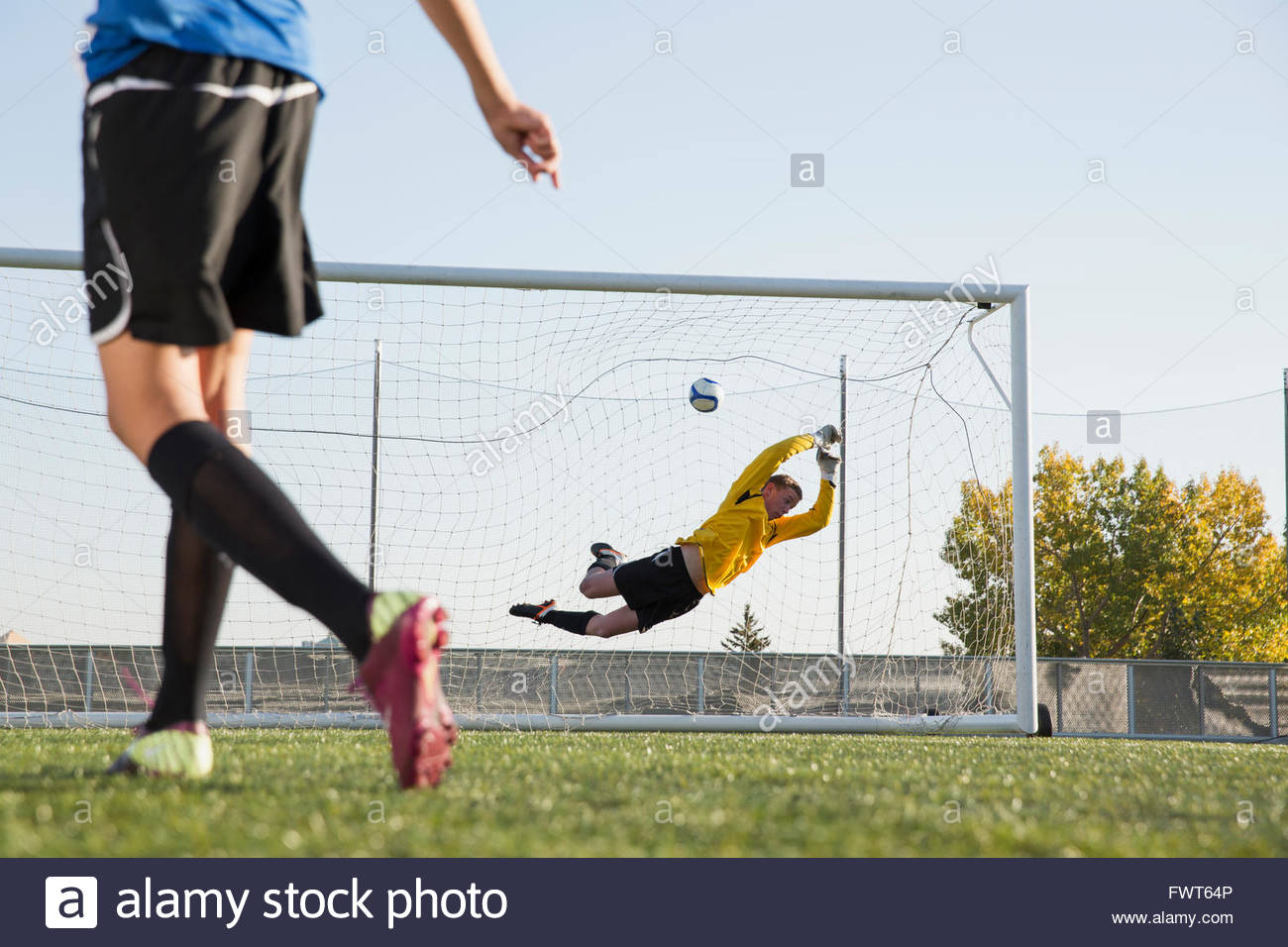 Soccer goalie attempting to stop soccer ball Stock Photo Alamy