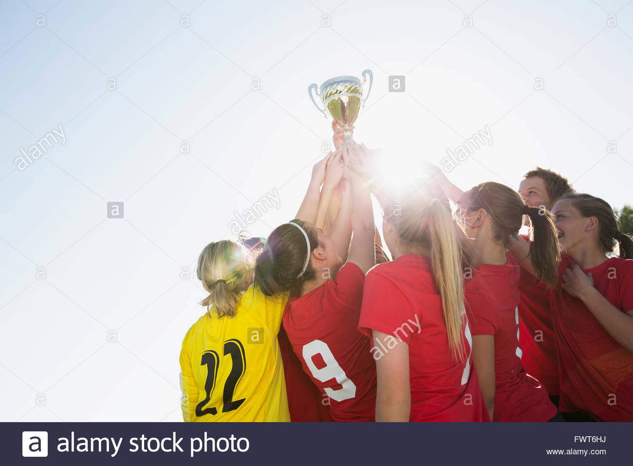 Soccer girls lifting trophy in celebration Stock Photo Alamy