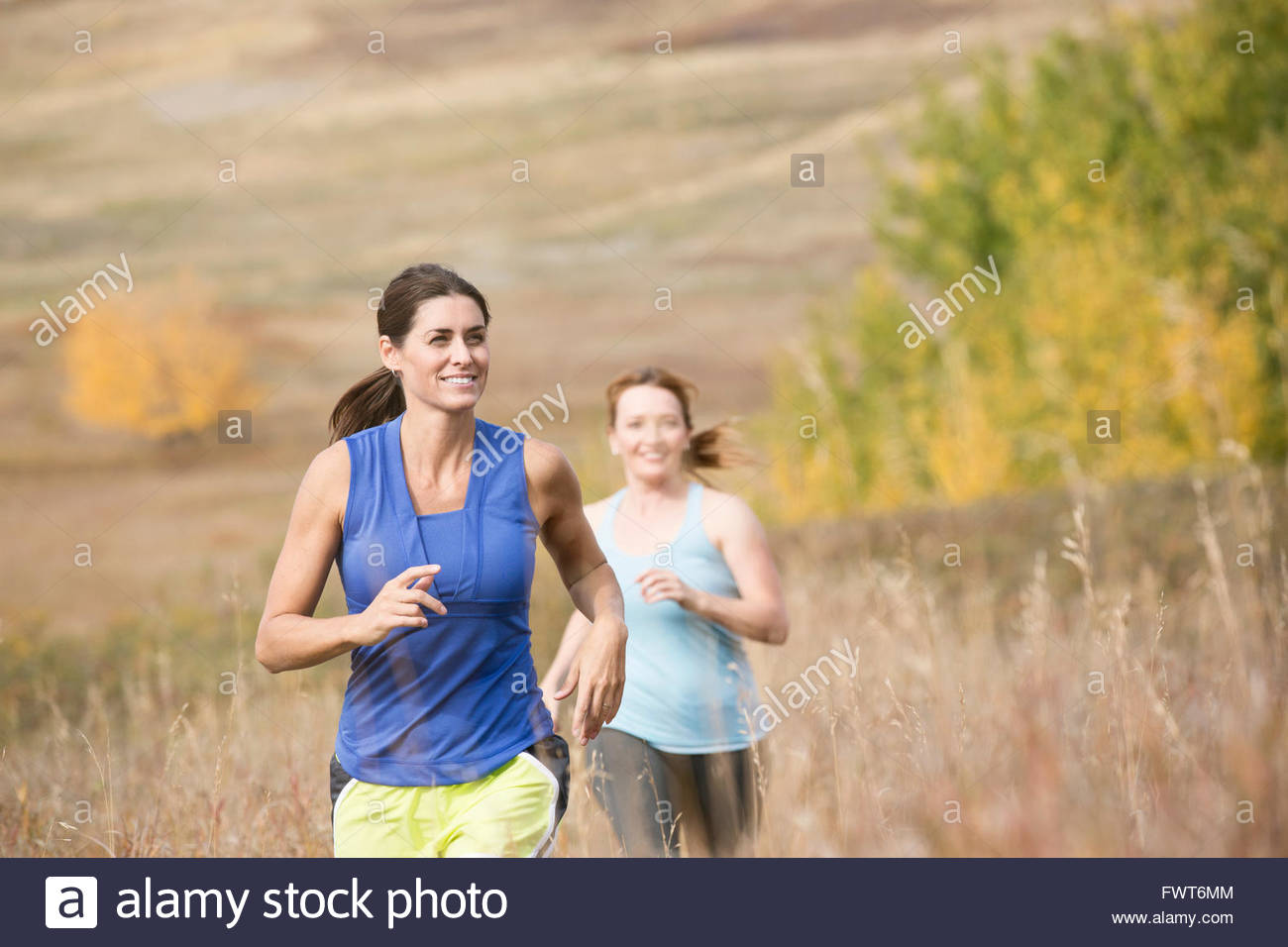 Two women running outdoors together Stock Photo Alamy