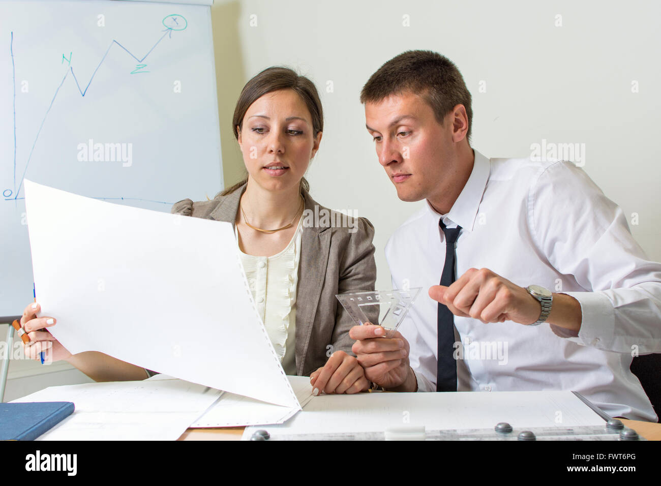 Couple of colleagues working on a project at the office Stock Photo