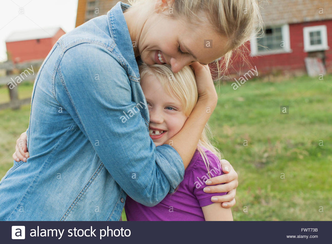 Mother and young daughter hugging outdoors. Stock Photo