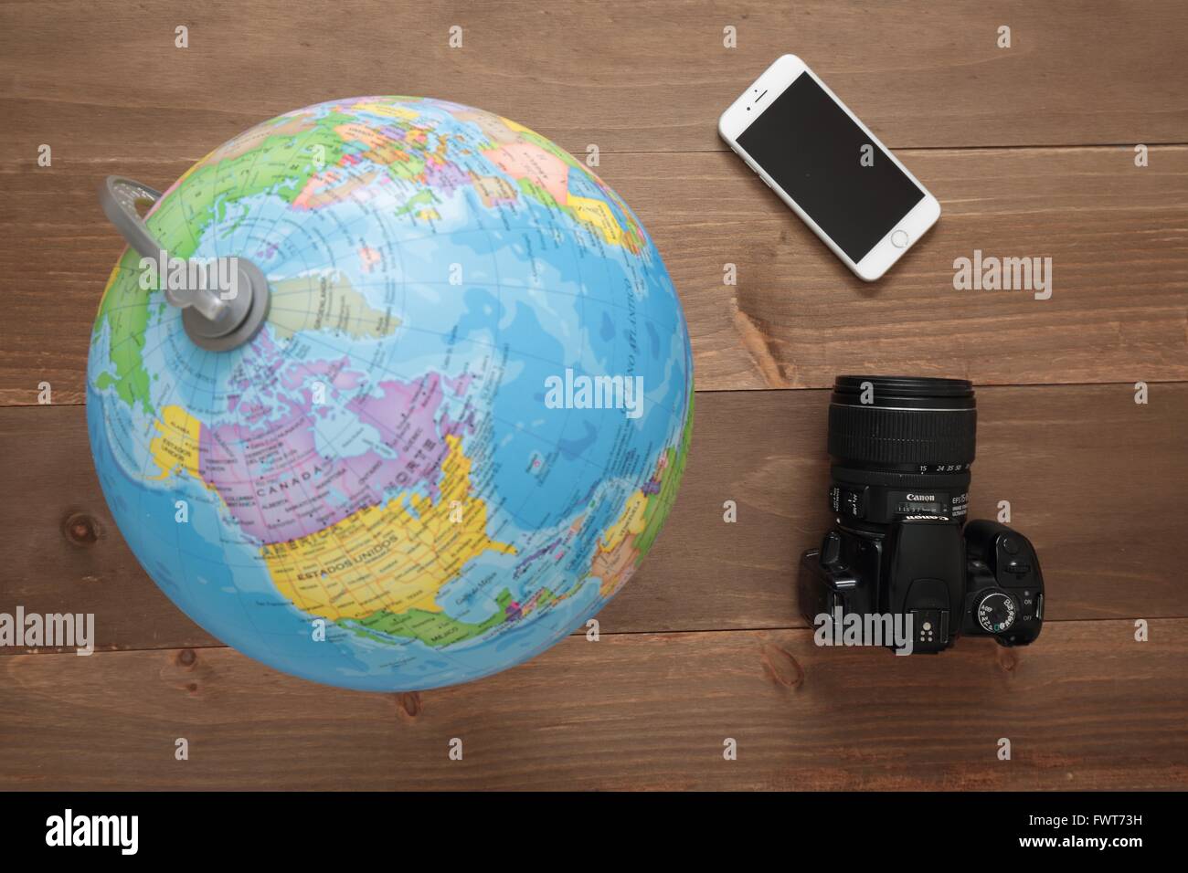 Elche, Spain. March 31, 2016: Globe, camera and mobile on wooden background Stock Photo