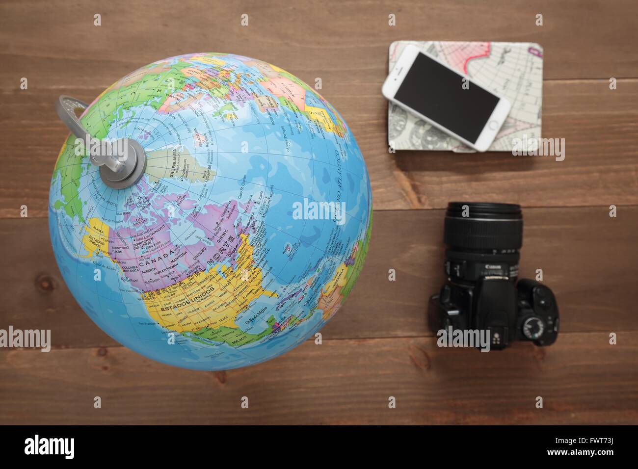 Elche, Spain. March 31, 2016: Globe, camera and mobile on wooden background Stock Photo
