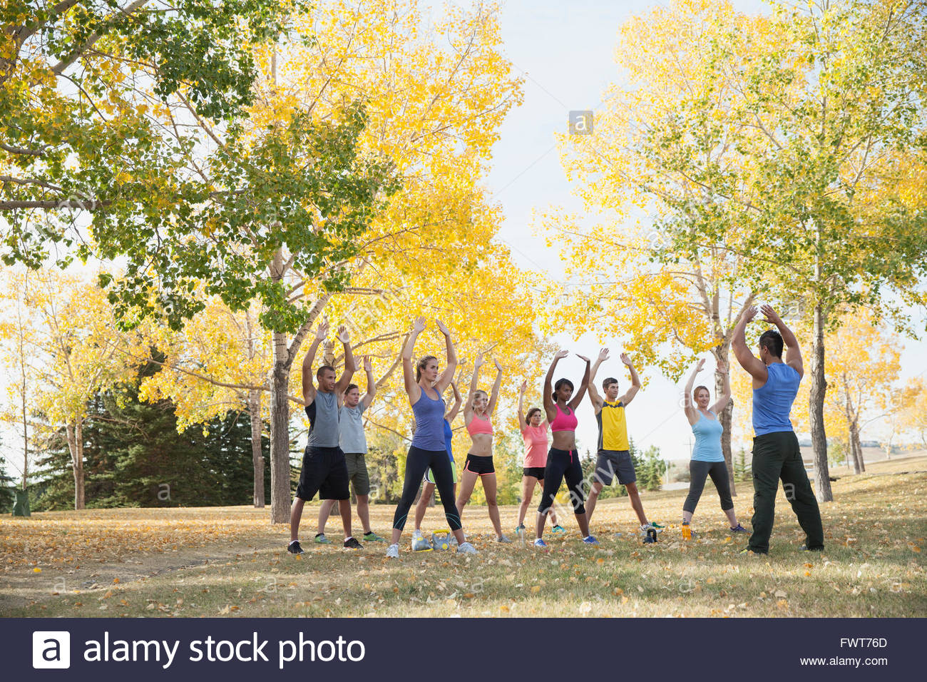 Coach leading people in outdoor fitness class Stock Photo Alamy