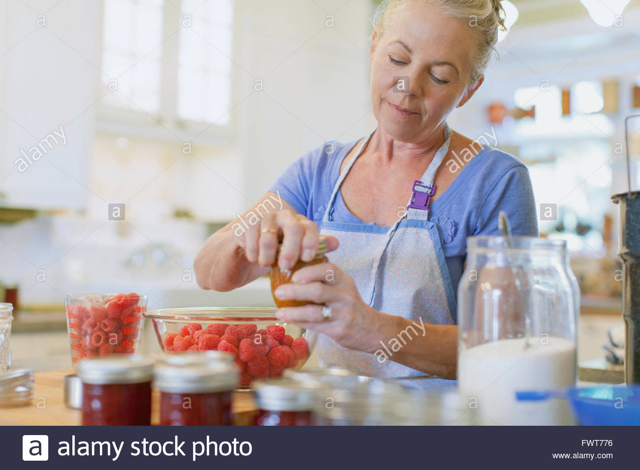 Woman making jam in kitchen Stock Photo Alamy