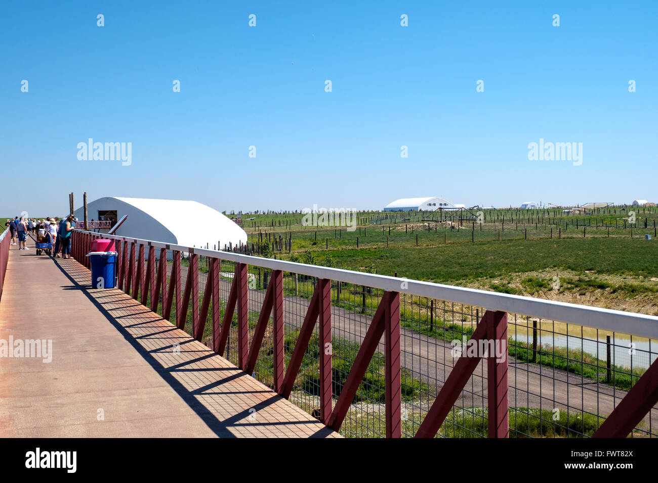 Visitors walk along the viewing area over various animal habitats at The Wild Animal Sanctuary. Stock Photo