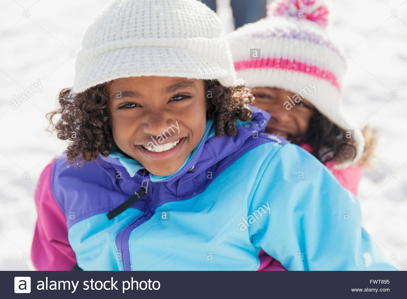 Portrait of happy sisters smiling outdoors in winter Stock Photo