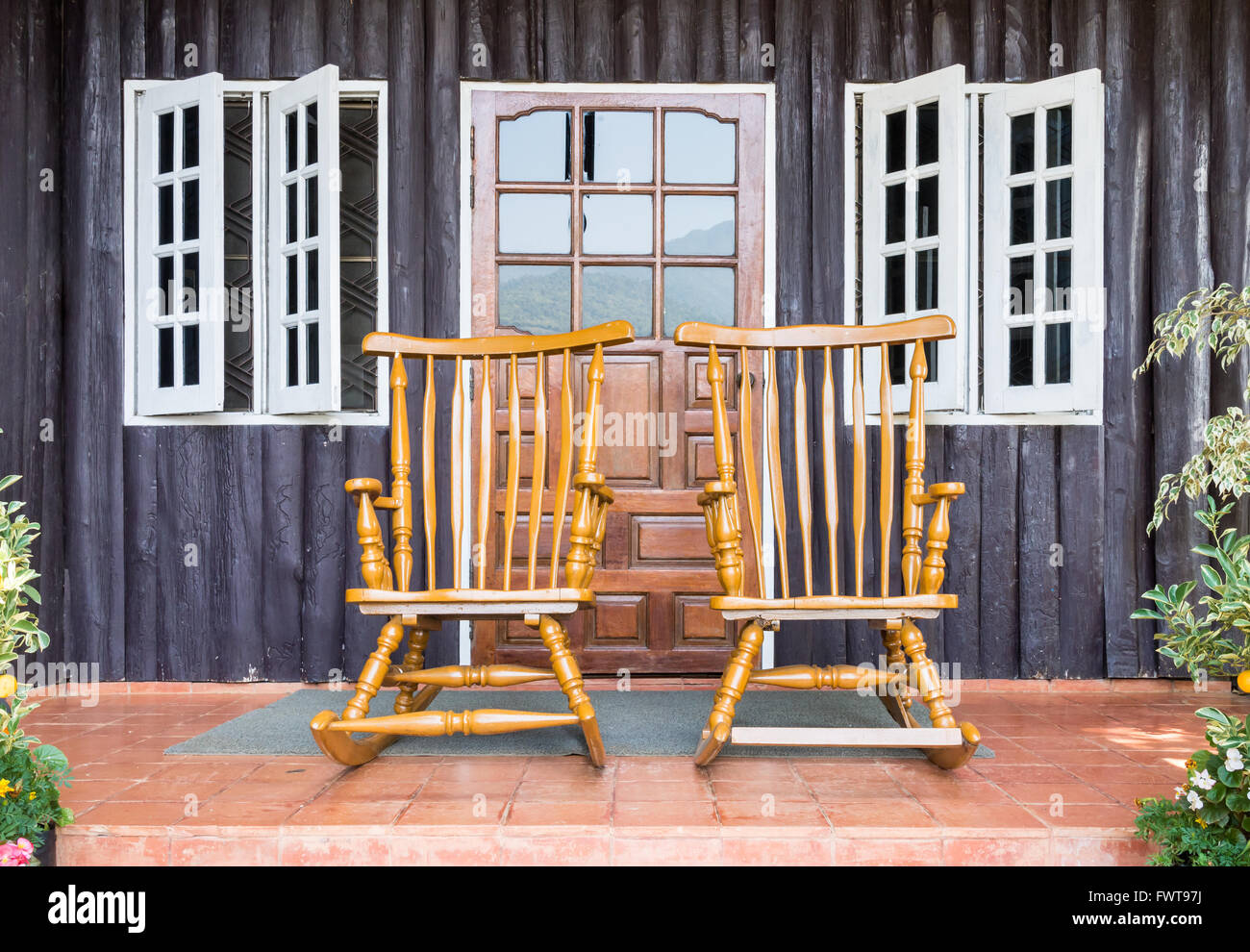 Wooden rocking chair  in front of the  countryside house. Stock Photo