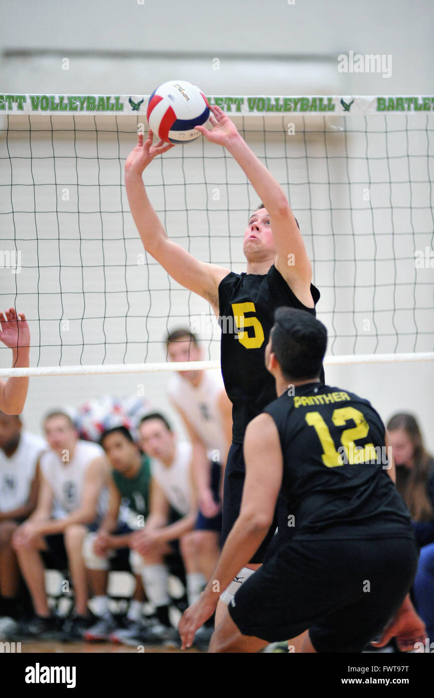 Player setting for a teammate prior to nailing down a match-winning point during a high school competition. USA. Stock Photo