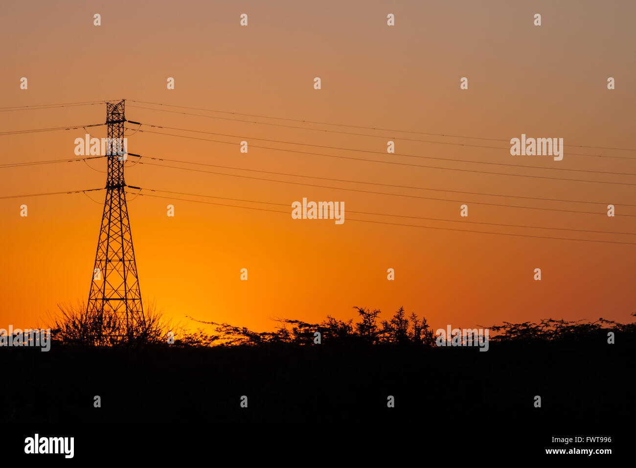 Silhouette of power lines and transmission towers at sunset Stock Photo ...