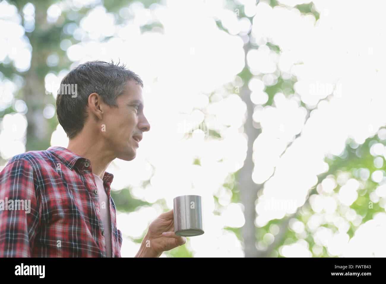 Caucasian man drinking coffee at a camp site Stock Photo