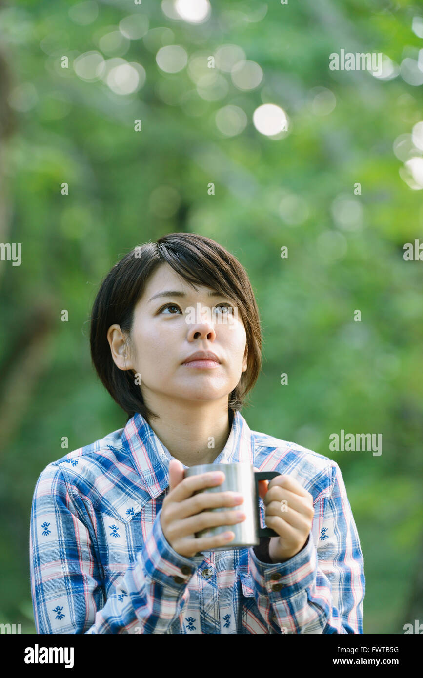Young Japanese woman drinking coffee at a camp site Stock Photo Alamy