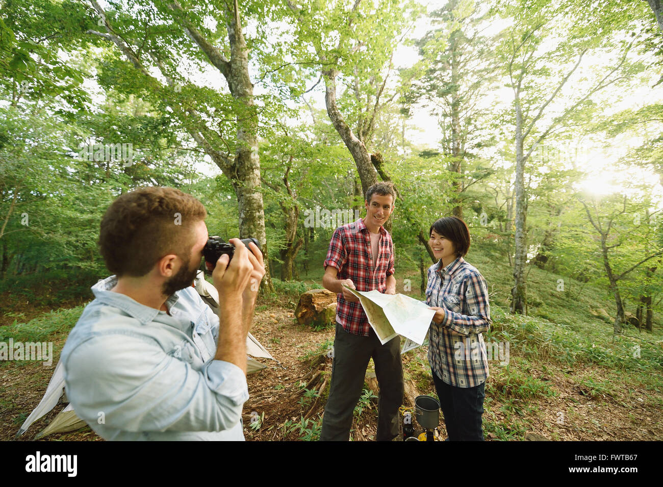 Multi-ethnic group of friends taking pictures at a camp site Stock Photo