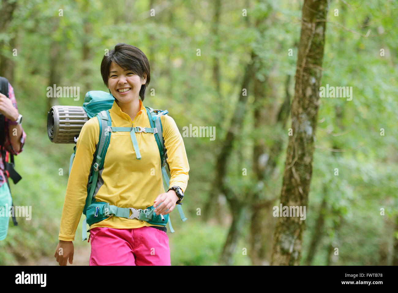 Young Japanese woman trekking in the woods Stock Photo