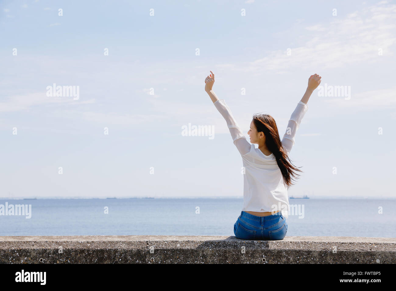Back view woman sitting on wall hi-res stock photography and images - Alamy