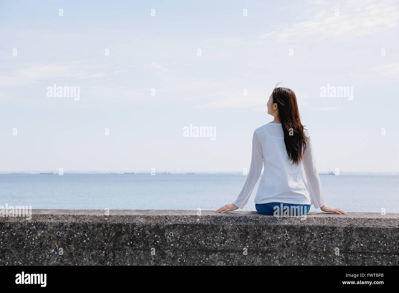 Back view woman sitting on wall hi-res stock photography and images - Alamy