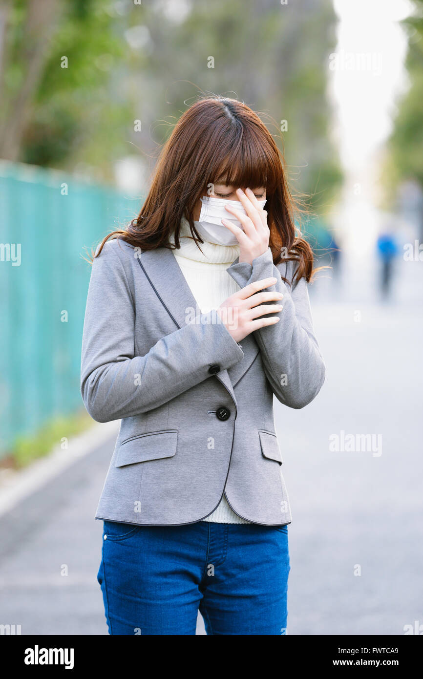 Attractive Japanese woman feeling sick on a Winter day Stock Photo