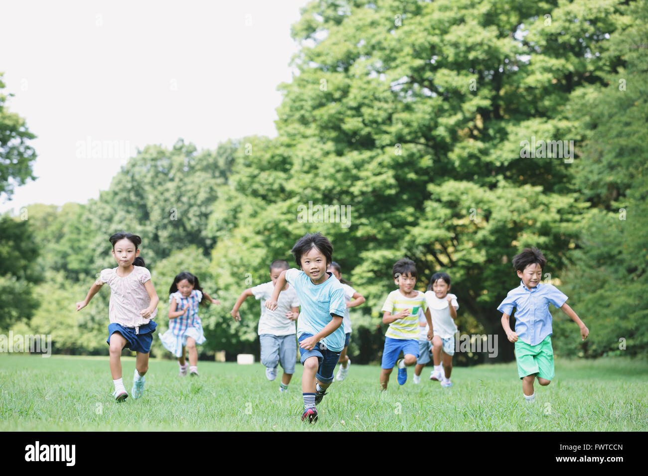 Japanese kids running in a city park Stock Photo Alamy