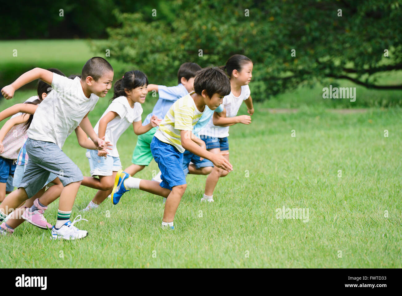 Japanese kids running in a city park Stock Photo Alamy