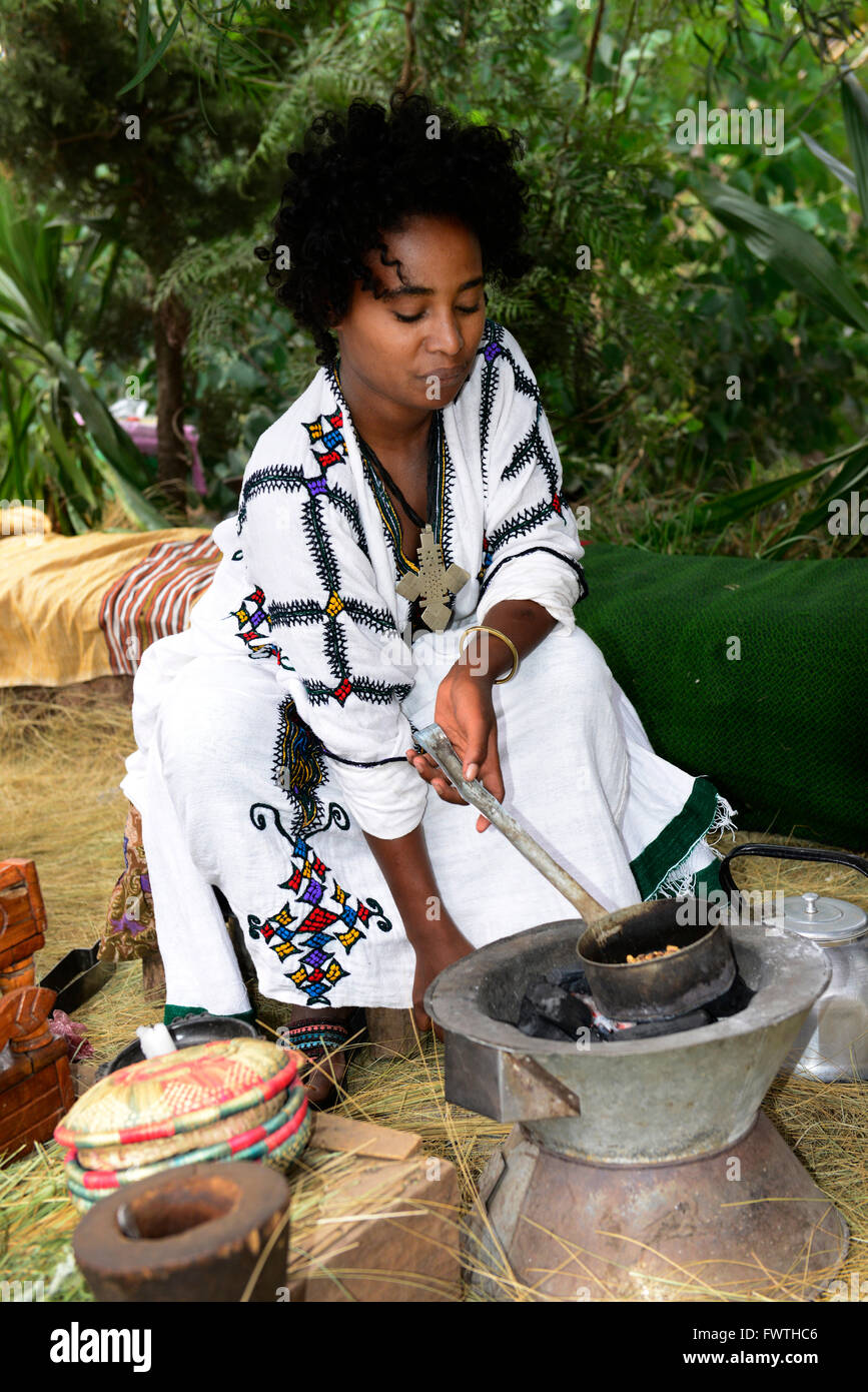 A young Ethiopian woman roasting the coffee beans during a traditional