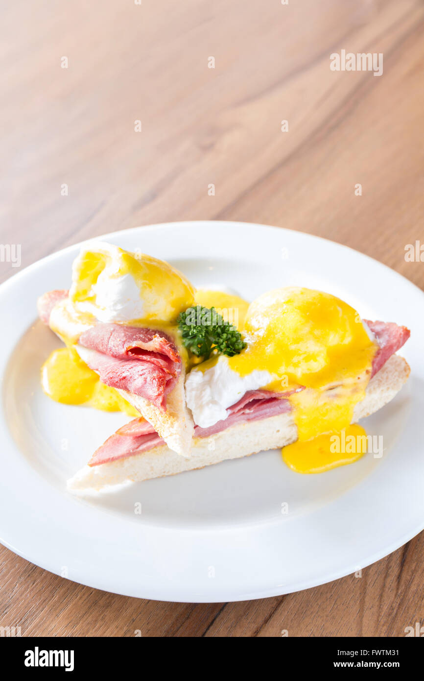 Eggs Benedict breakfast- toasted English muffins, ham, poached eggs, with buttery hollandaise sauce Stock Photo