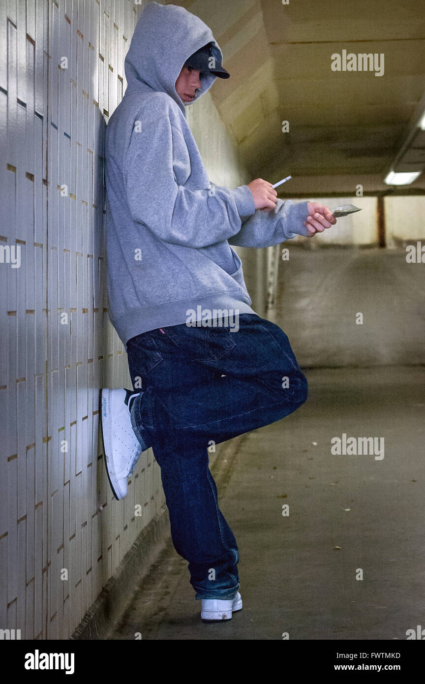 A model poses as a hooded teenage drug dealer selling weed in an
