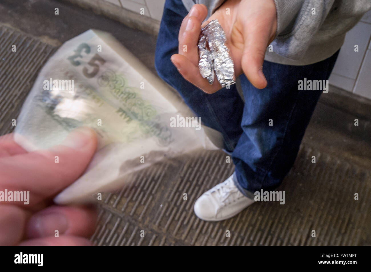 A model poses as a hooded teenage drug dealer selling weed in an underpass. Stock Photo