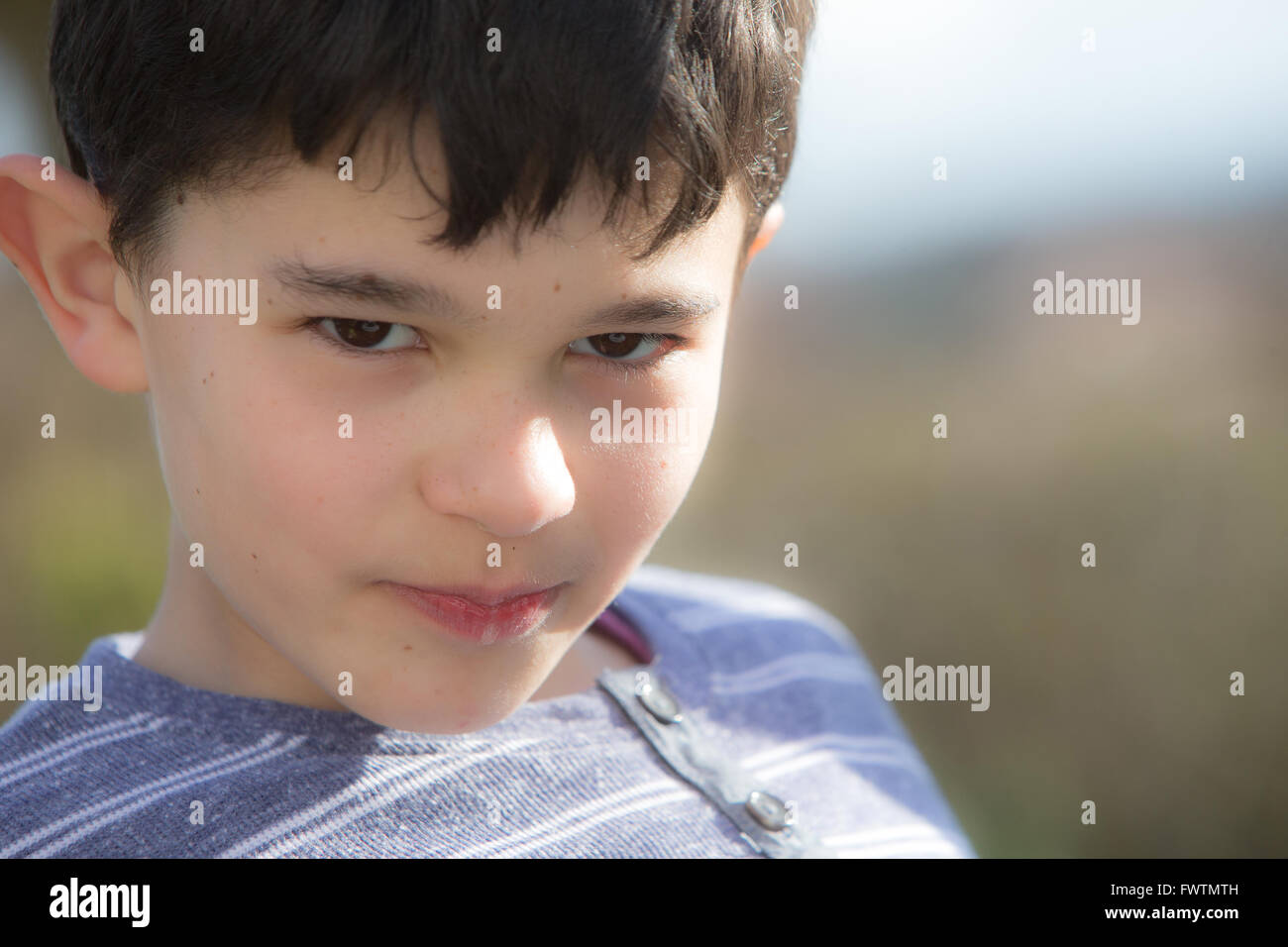 Boy looking cheeky and mischievous Stock Photo