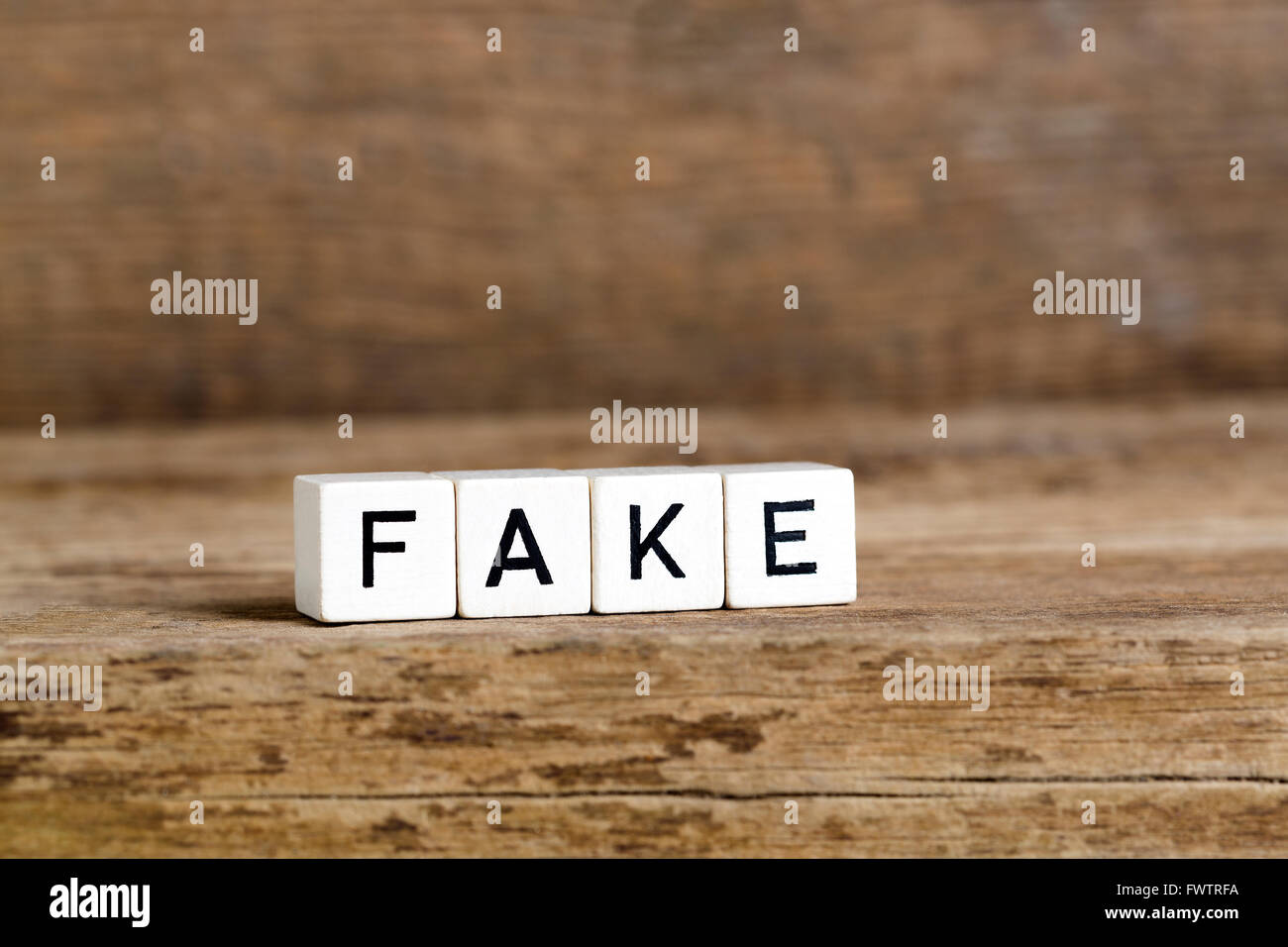 The word fake written in cubes on wooden background Stock Photo Alamy