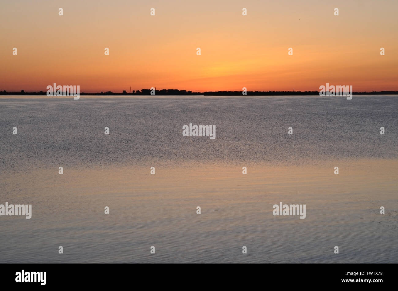 Reflection of the sunset in calm waters of a lowland river (Northern Dvina), Arkhangelsk, Russia Stock Photo