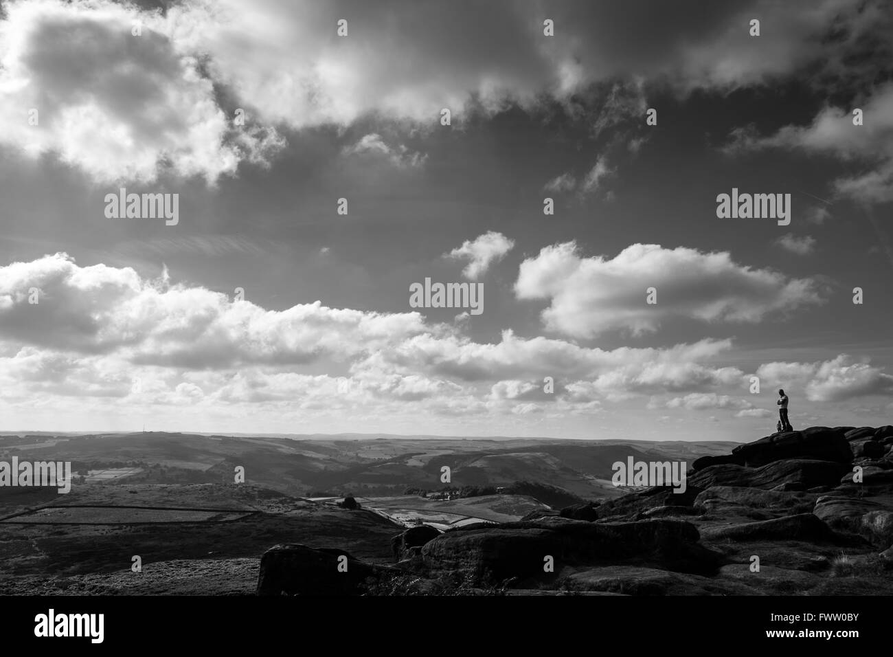 A rambler / walker standing at Stanage Edge in the Peak District National Park near Sheffield Stock Photo