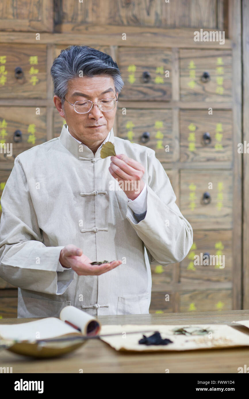 Senior Chinese doctor checking medicinal herbs Stock Photo Alamy