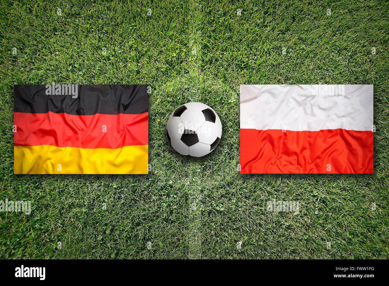 Germany vs. Poland flags on green soccer field Stock Photo