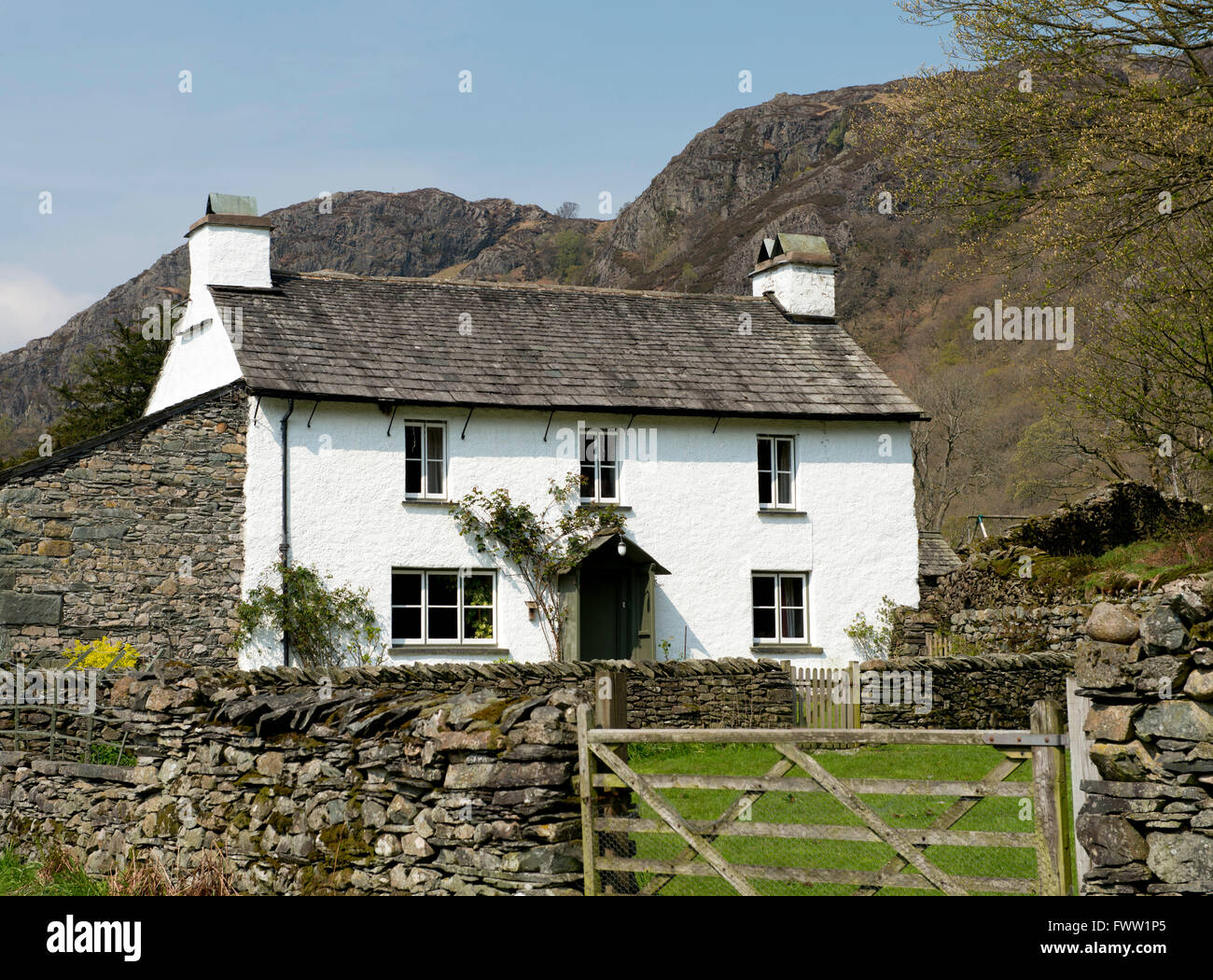 Yew Tree Cottage, a traditonal white farm house with a slate roof near