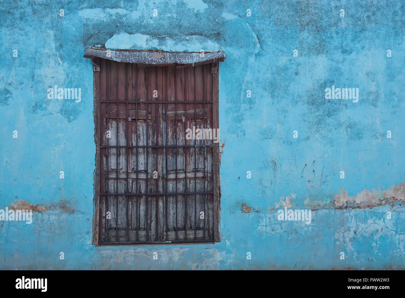 A blue wall and shuttered window in the old Cuban town of Trinidad. Stock Photo