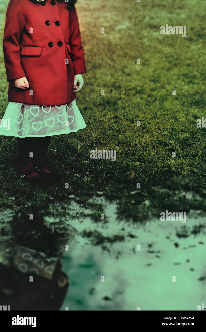 small girl standing by the puddle Stock Photo