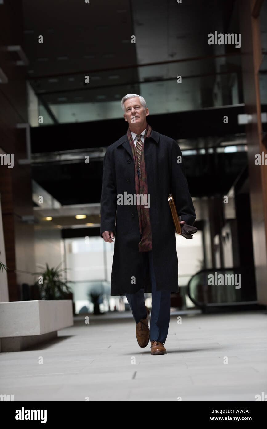 handsome and sucessful senior business man walking in modern office ...