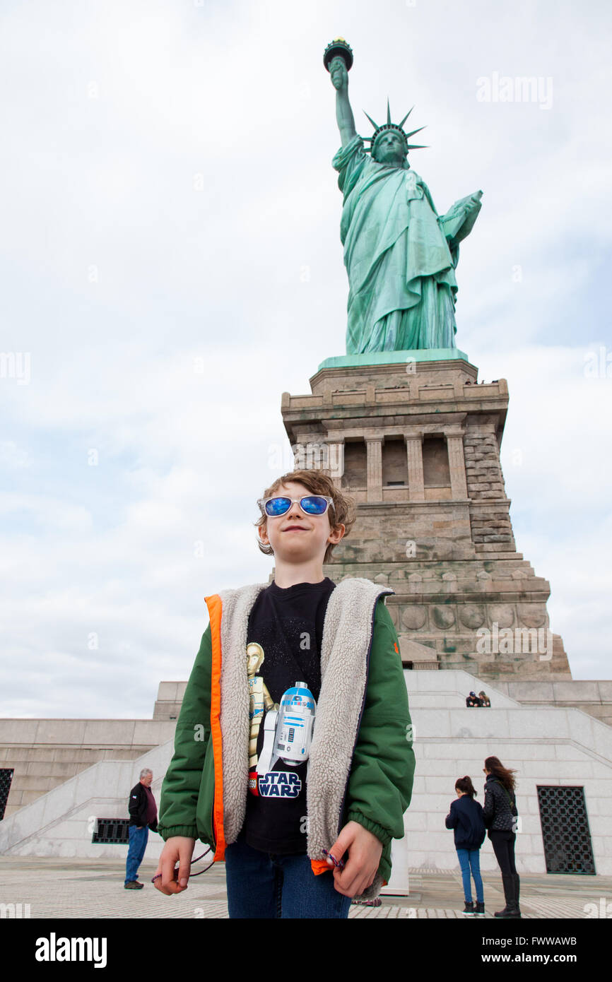 Six year old boy standing in front of the Statue of Liberty, New York City, Liberty Island, ,New York, United States of America. Stock Photo