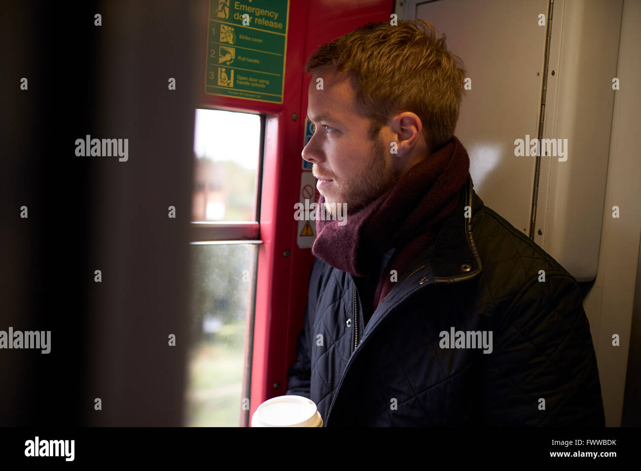 Young Man Standing In Train Carriage On Railway Journey Stock Photo